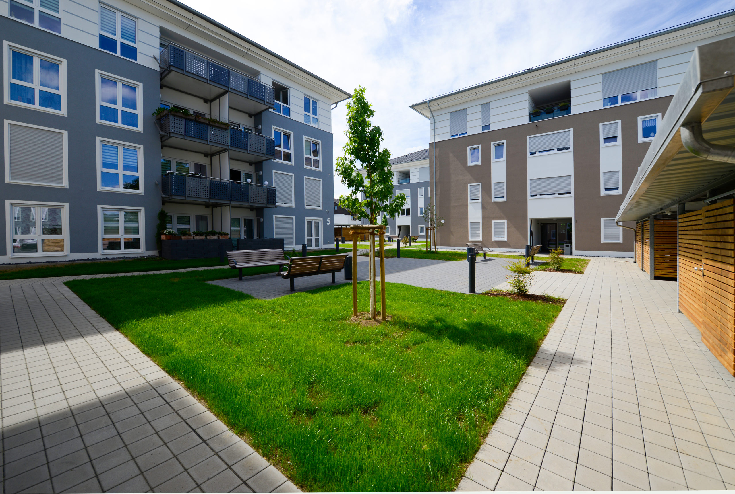Zeppelinhof-21 Moderner Wohnkomplex mit gepflegtem Garten Innenhof, Grünflächen und Sitzbänken zwischen den Wohngebäuden