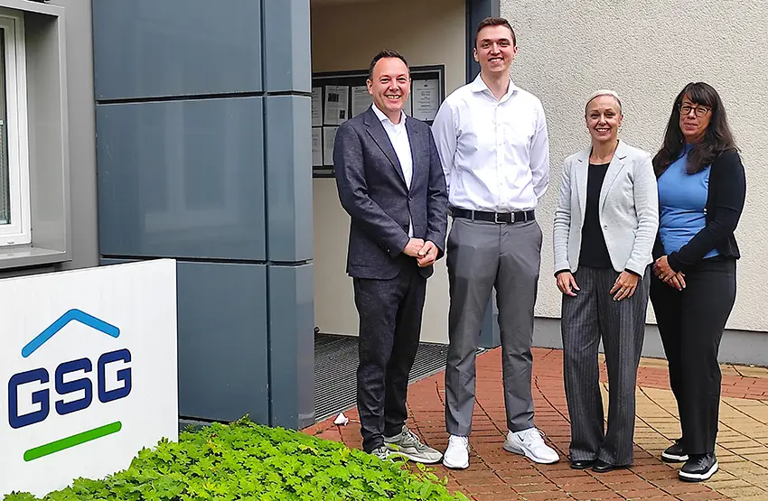 Vier Personen posieren vor einem GSG Firmengebäude für ein Gruppenfoto