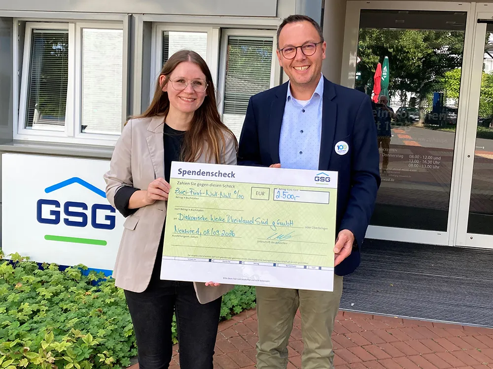 Zwei Personen halten einen Spendenscheck der GSG über 3.500 Euro für die Diakonie