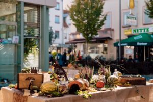 Neuwzied-Markttage 2026_Zimpfer-Photography Herbstlich dekorierter Marktstand mit Kürbissen, Vögeln und Pflanzen bei den Neuwieder Markttagen